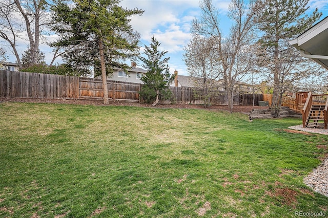 7746 W Quarto Dr, Littleton, CO 80128 - view of yard with a fenced backyard, a wooden deck, and stairs