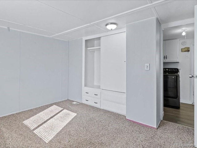 unfurnished bedroom featuring a closet, carpet, and washer / clothes dryer