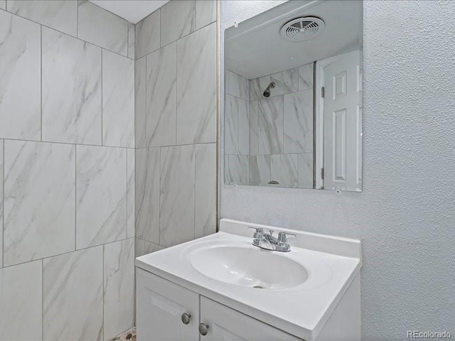 bathroom featuring vanity and a tile shower