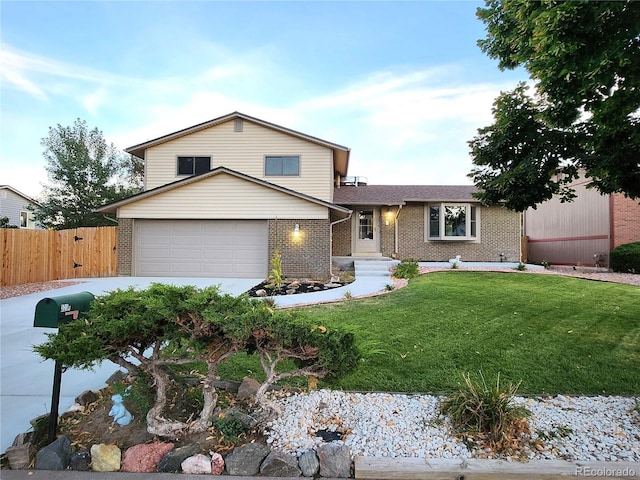 tri-level home with fence, driveway, a front lawn, brick siding, and a garage