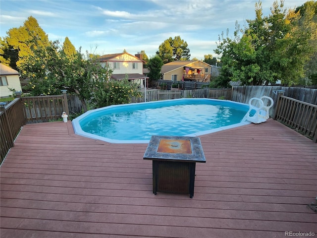 view of pool with an outdoor fire pit, a fenced backyard, a fenced in pool, and a wooden deck