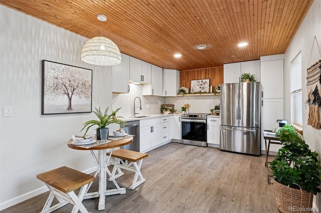 kitchen featuring light countertops, light wood-style flooring, appliances with stainless steel finishes, wood ceiling, and a sink