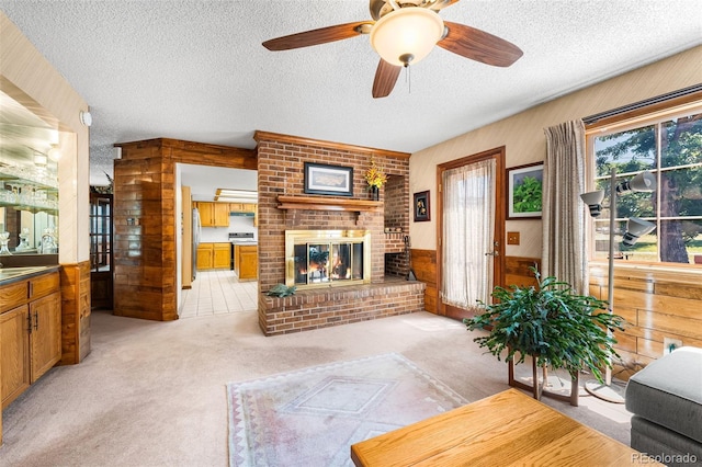 16085 E Lehigh Cir, Aurora, CO 80013 - living room with a textured ceiling, a fireplace, light carpet, ceiling fan, and wooden walls