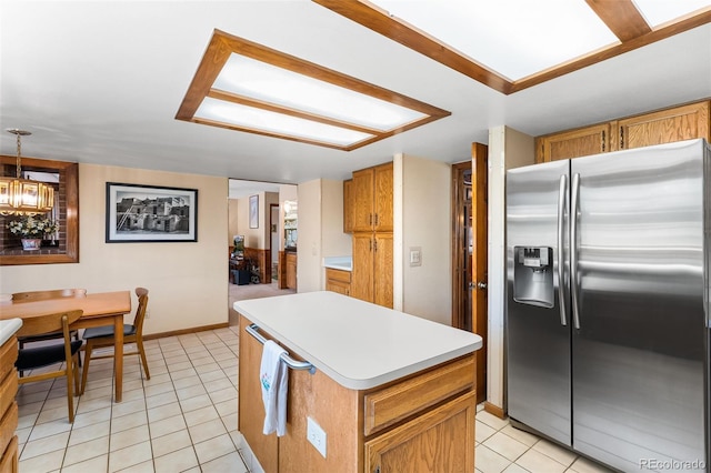 16085 E Lehigh Cir, Aurora, CO 80013 - kitchen with stainless steel fridge, light tile patterned floors, light countertops, a center island, and a chandelier