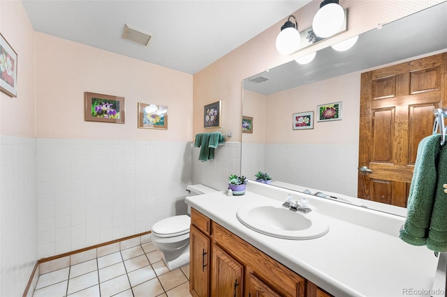 16085 E Lehigh Cir, Aurora, CO 80013 - bathroom featuring vanity, tile walls, tile patterned flooring, and a wainscoted wall