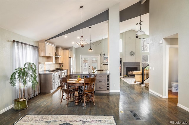 dining space with visible vents, baseboards, a fireplace, high vaulted ceiling, and dark wood-style flooring