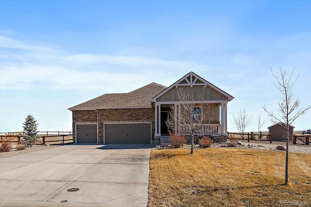 view of front of house with a garage, covered porch, driveway, and fence