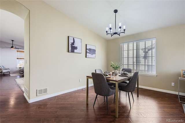 dining area with vaulted ceiling, dark hardwood / wood-style flooring, and ceiling fan with notable chandelier