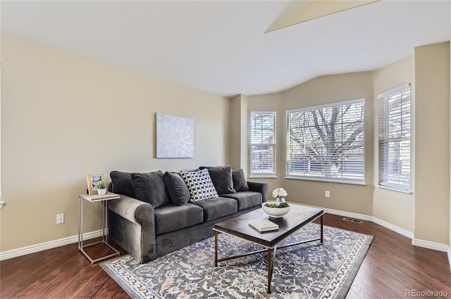 living room featuring a wealth of natural light, dark hardwood / wood-style flooring, and vaulted ceiling