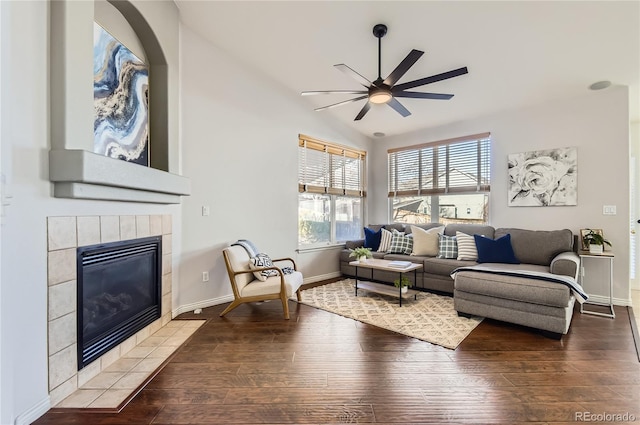 living room with a tile fireplace, ceiling fan, lofted ceiling, and hardwood / wood-style flooring