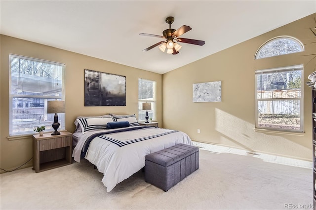 carpeted bedroom with multiple windows, ceiling fan, and lofted ceiling