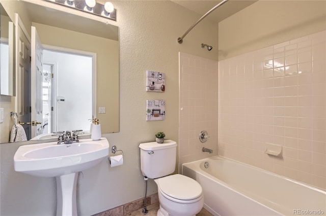 bathroom with toilet and tiled shower / bath