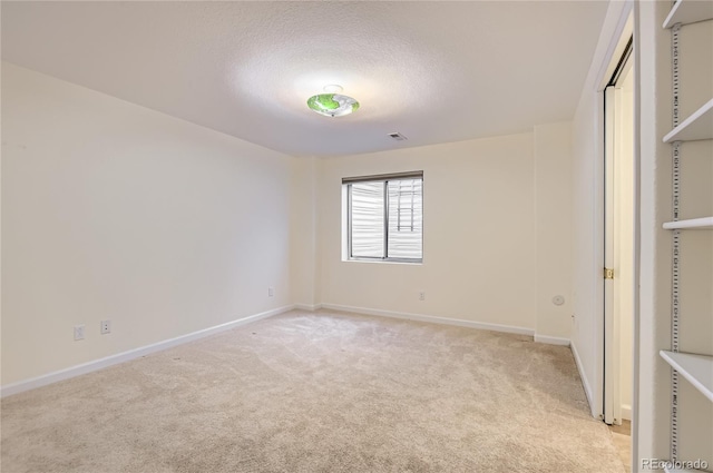 unfurnished bedroom featuring a textured ceiling and light carpet