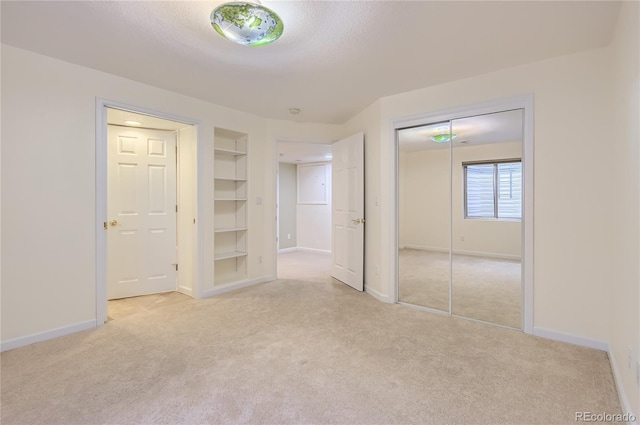 unfurnished bedroom featuring light carpet and a textured ceiling