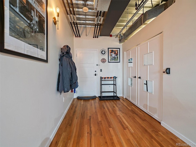 corridor featuring wood finished floors and baseboards
