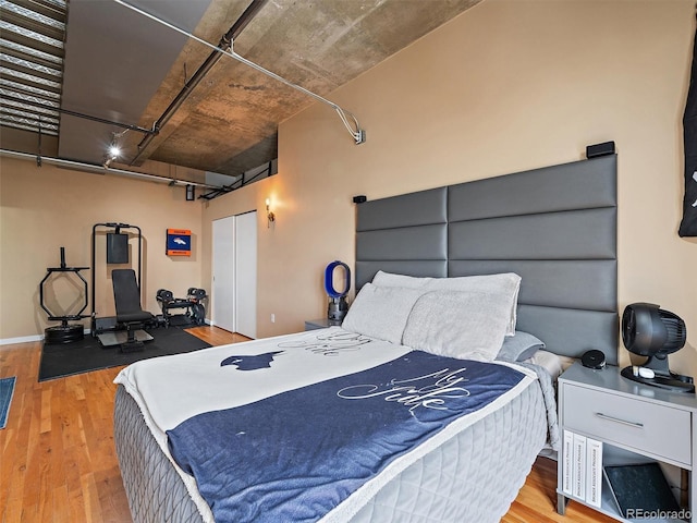 bedroom with wood finished floors, a garage, and a closet