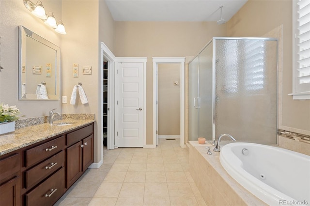 bathroom with a stall shower, tile patterned flooring, a jetted tub, and vanity