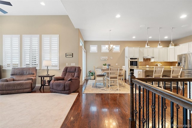 living area with dark wood-style floors, a chandelier, and recessed lighting