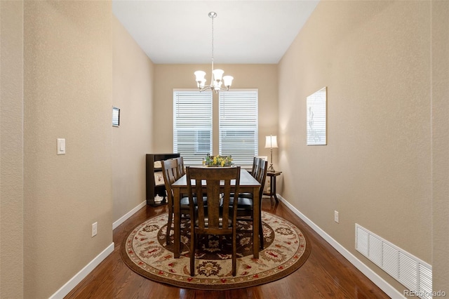 dining room with baseboards, a notable chandelier, visible vents, and dark wood-type flooring