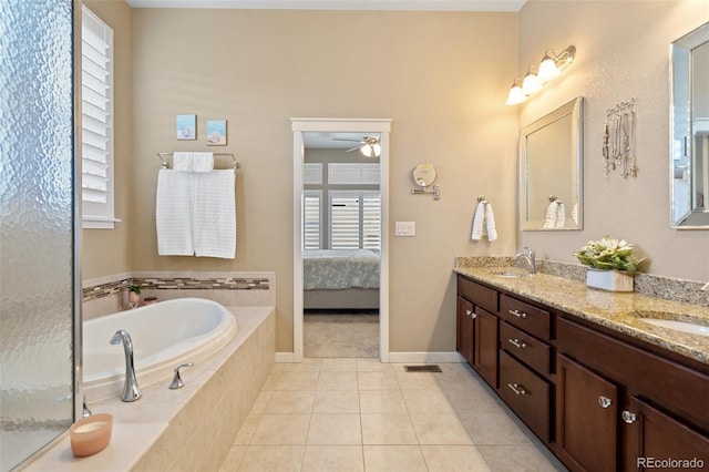 ensuite bathroom with double vanity, a sink, a bath, and tile patterned floors