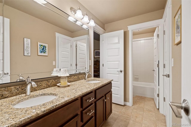 bathroom with double vanity, baseboards, and a sink