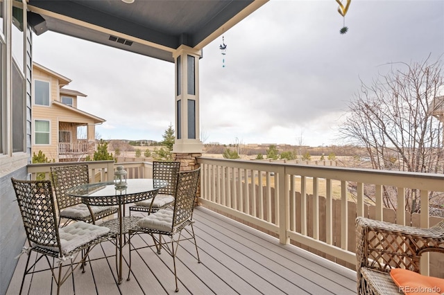 deck with outdoor dining area and visible vents