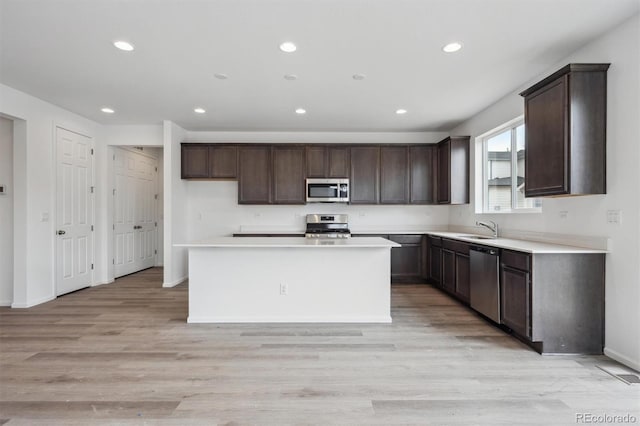 6625 N Nepal St, Aurora, CO 80019 - kitchen featuring recessed lighting, dark brown cabinets, appliances with stainless steel finishes, a sink, and light wood-style floors