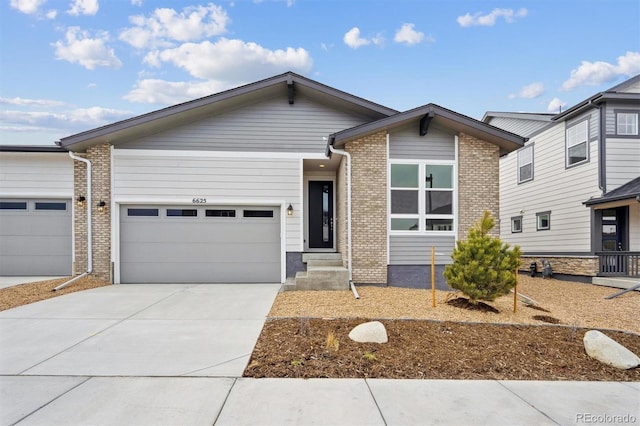 6625 N Nepal St, Aurora, CO 80019 - view of front of house with driveway, brick siding, and a garage