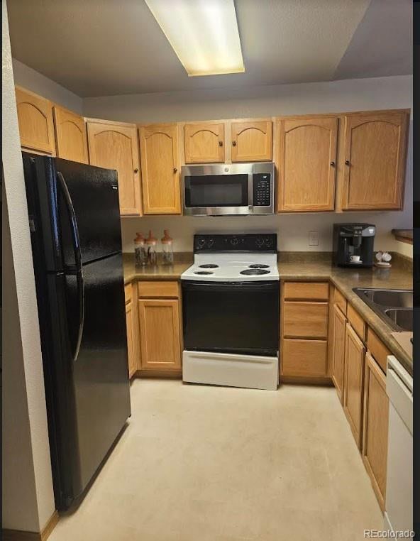 kitchen with light brown cabinets, sink, and white appliances