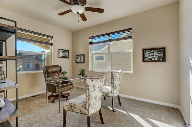 carpeted home office with ceiling fan and plenty of natural light