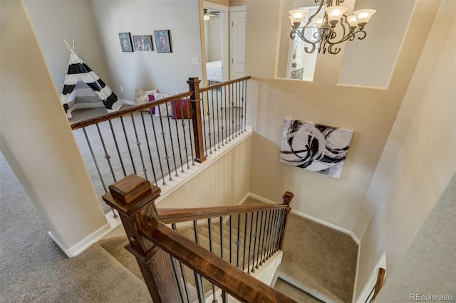 staircase featuring carpet flooring and a chandelier