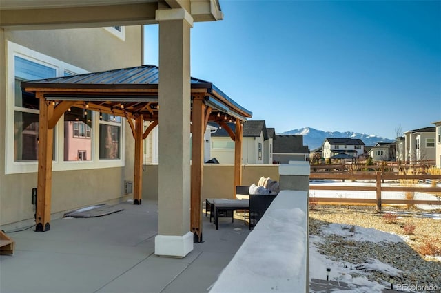 snow covered patio featuring a gazebo and a mountain view