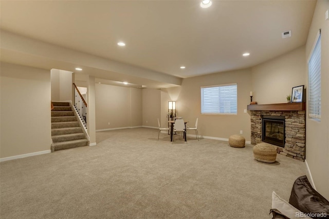 sitting room with recessed lighting, light carpet, a fireplace, and stairs