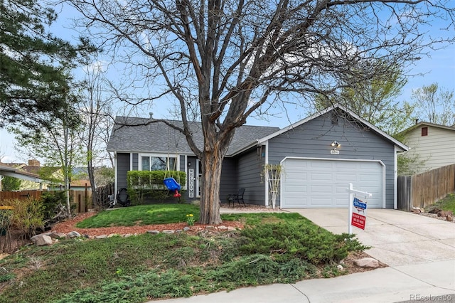 ranch-style house with roof with shingles, driveway, fence, a garage, and a front yard