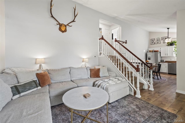 living room with vaulted ceiling, dark wood-style floors, and stairs