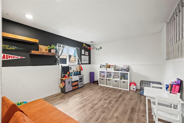 playroom with recessed lighting, wood finished floors, and a textured ceiling