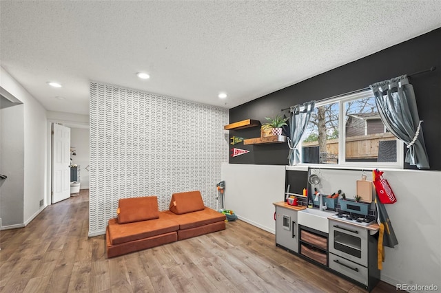 interior space with recessed lighting, wood finished floors, a textured ceiling, and baseboards