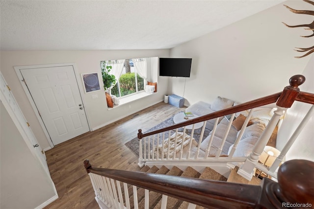 stairway with wood finished floors and baseboards