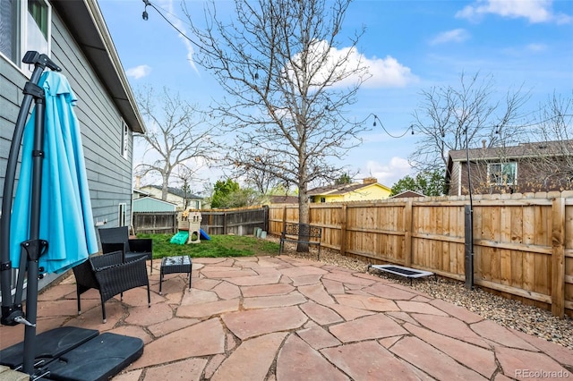 view of patio / terrace with a fenced backyard and a playground