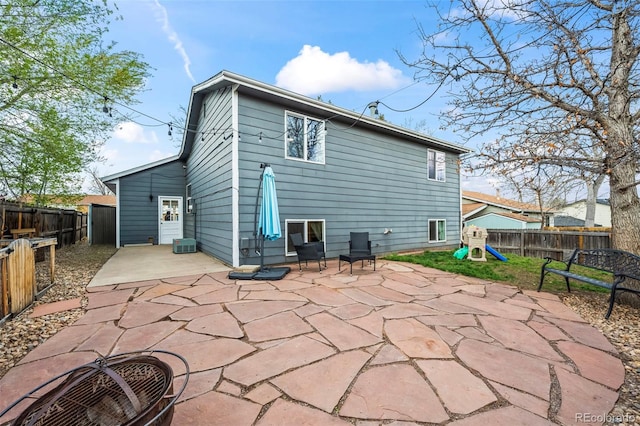 back of property featuring a patio, a fenced backyard, and a playground