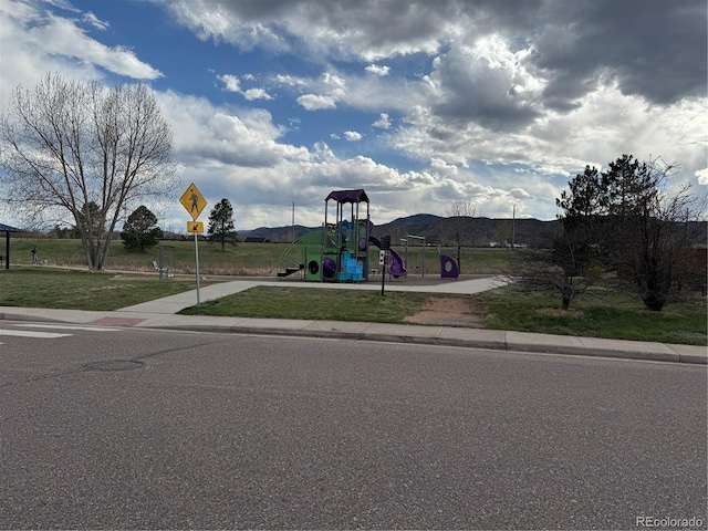 community play area featuring a lawn and a mountain view