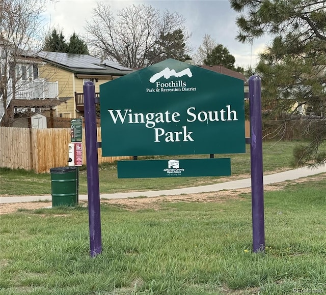 community sign with fence and a yard