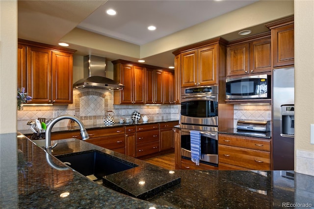 4373 E Phillips Pl, Centennial, CO 80122 - kitchen with a sink, dark stone countertops, stainless steel appliances, recessed lighting, and wall chimney exhaust hood