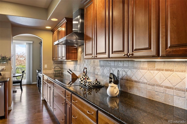 4373 E Phillips Pl, Centennial, CO 80122 - kitchen featuring baseboards, black electric stovetop, wall chimney range hood, arched walkways, and dark stone countertops