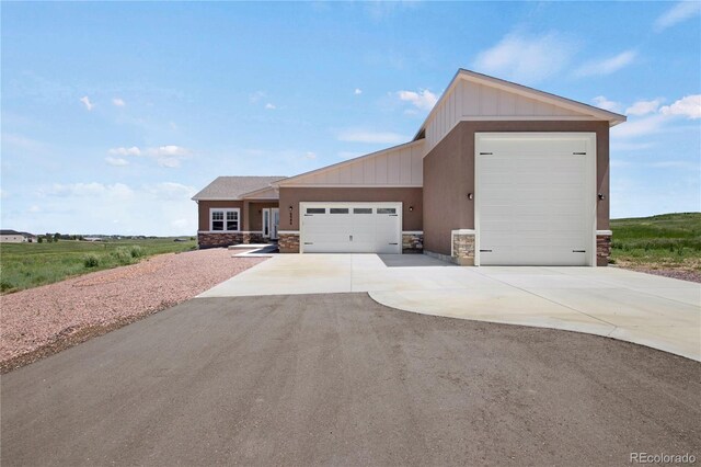 6986 Marshbern Ct, Colorado Springs, CO 80908 - view of front of property featuring stone siding, an attached garage, concrete driveway, and board and batten siding