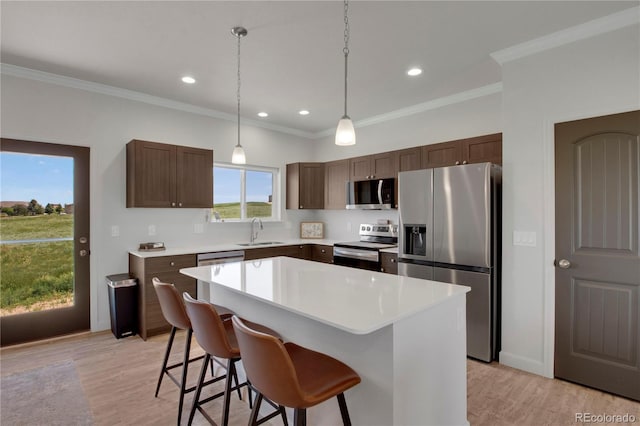 6986 Marshbern Ct, Colorado Springs, CO 80908 - kitchen featuring stainless steel appliances, a center island, a breakfast bar, light countertops, and light wood-style floors