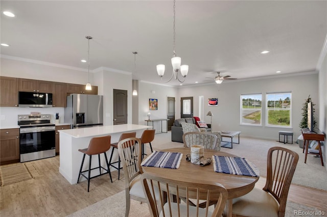 6986 Marshbern Ct, Colorado Springs, CO 80908 - dining room featuring recessed lighting, crown molding, light wood-style floors, a ceiling fan, and a chandelier