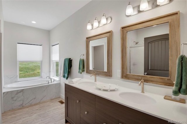 6986 Marshbern Ct, Colorado Springs, CO 80908 - full bath with a bath, double vanity, wood finished floors, and a shower with door