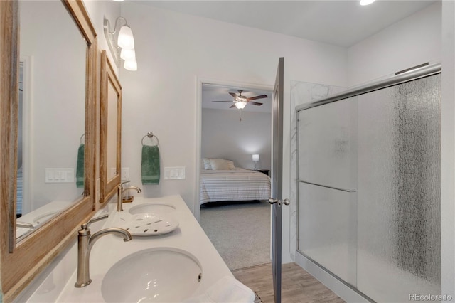 6986 Marshbern Ct, Colorado Springs, CO 80908 - full bathroom featuring ensuite bath, a stall shower, a ceiling fan, double vanity, and wood finished floors
