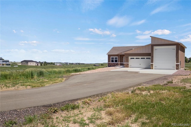 6986 Marshbern Ct, Colorado Springs, CO 80908 - view of front of property featuring driveway, an attached garage, stone siding, and board and batten siding